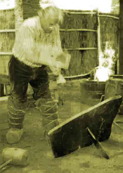 Franois Ilias en train d'abattre au muse de l'ardoise de Trlaz (F), coups de masse en bois sur le ct oppos  l'entaille